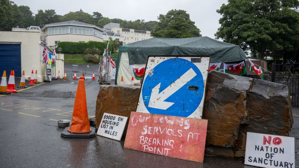 Protest signs and a barricade outside Stradey Park Hotel