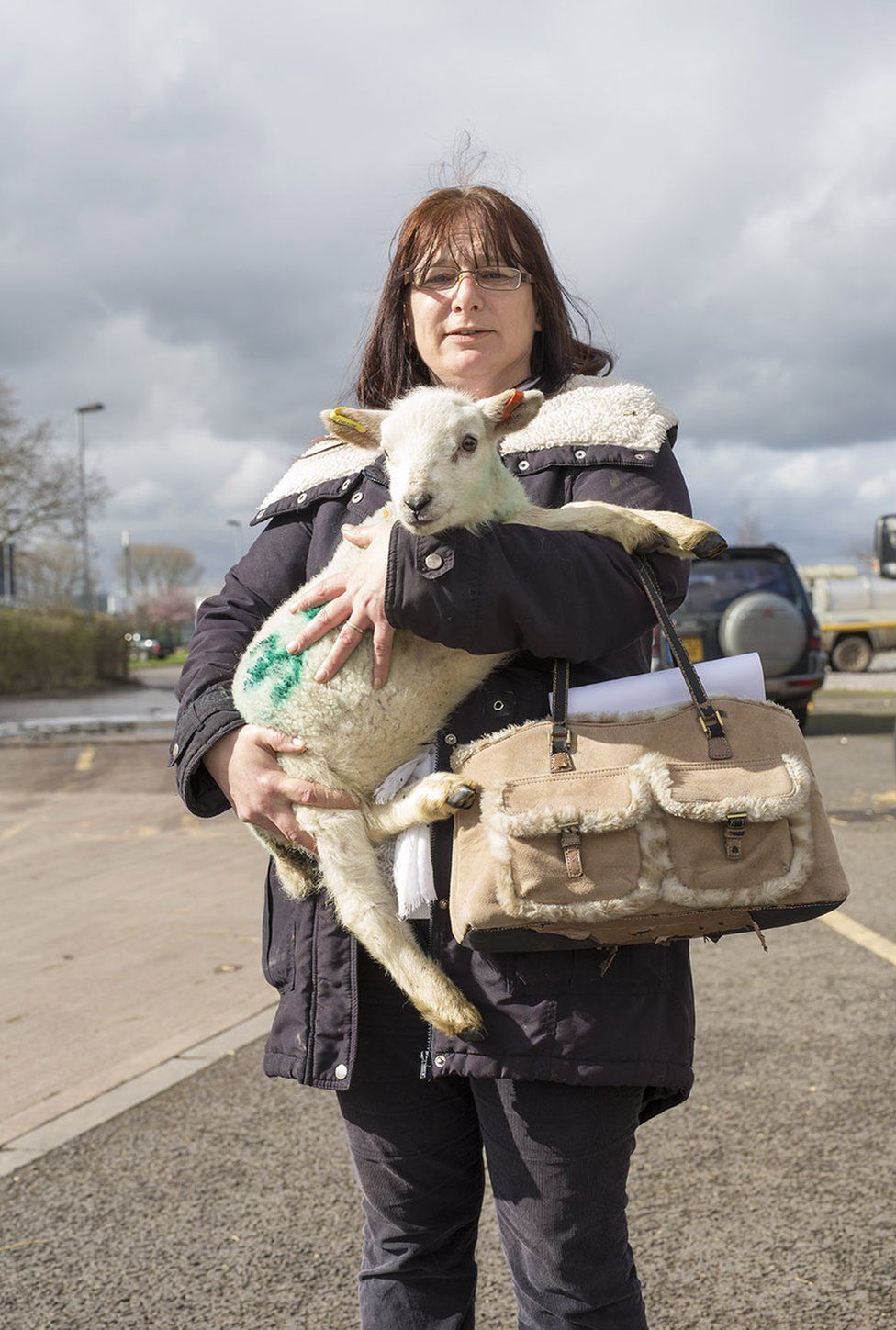 A woman holds a lamb