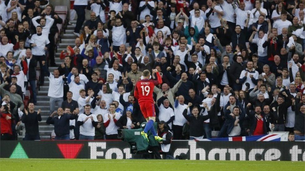 Wayne Rooney celebrates in front of England football fans