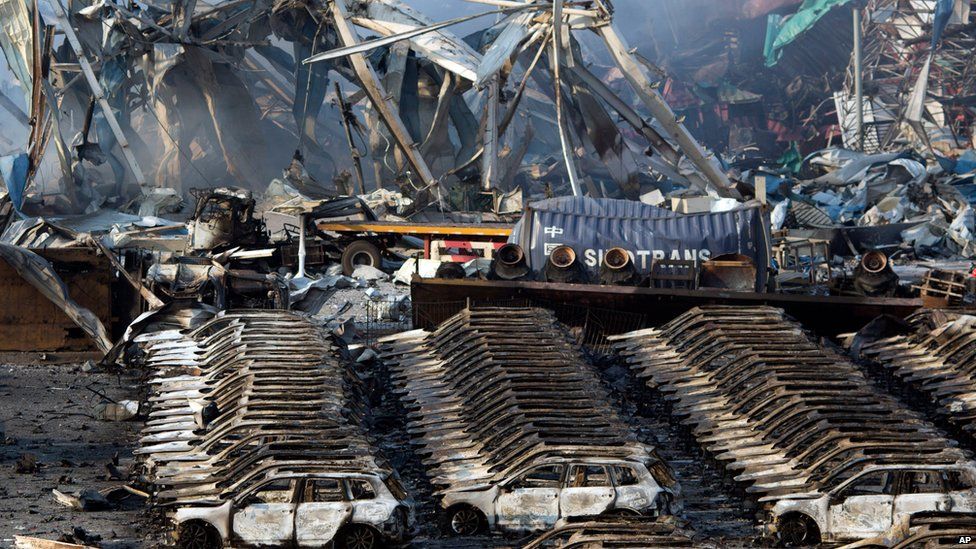 Charred remains of a warehouse and new cars are left burned after an explosion at a warehouse in Tianjin, Aug. 13, 2015
