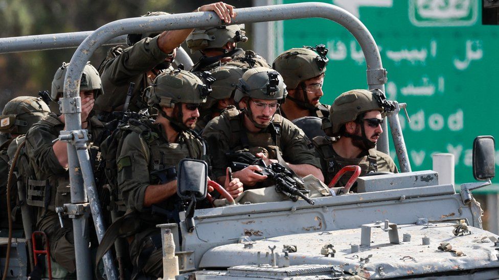 Militares israelenses avançam em uma estrada no sul de Israel, enquanto foguetes são lançados da Faixa de Gaza, nos arredores de Sderot, 7 de outubro de 2023