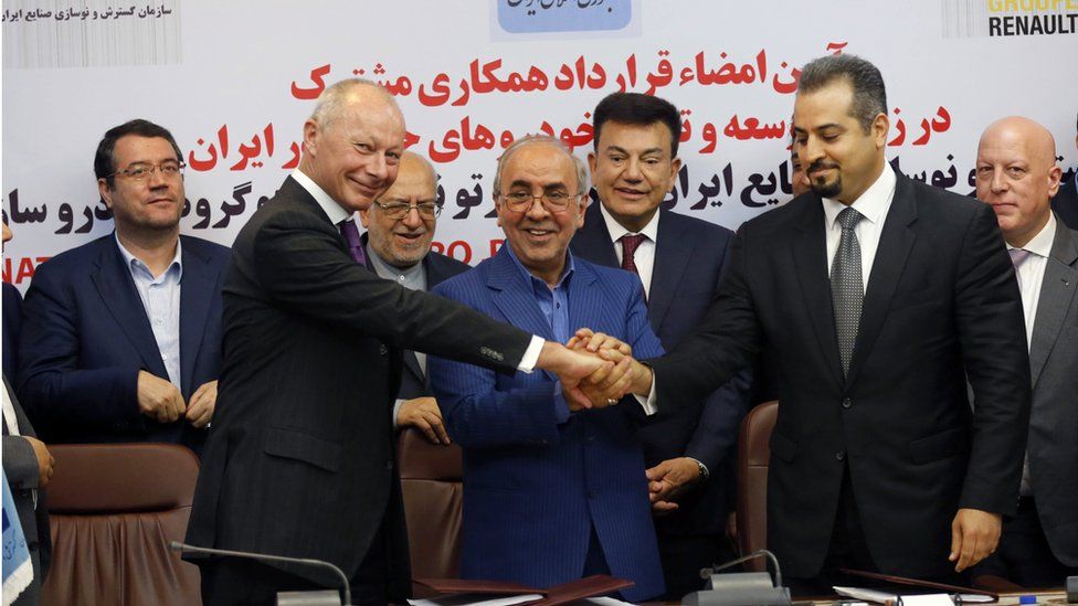 Thierry Bollore (L), deputy director in Competitiveness at Renault Group and Mansour Moazami (C) Chairman of the Board of Directors of IDRO Group, and Kourosh Morshed Solouki (R), deputy director of the Iranian Automobile Importers Association shake hands as Commerce Minister Mohammad Reza Nematzadeh (2-L back), looks on after during signing documents in Tehran, Iran, 07 August 2017.
