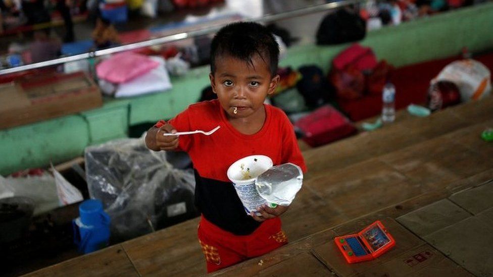 A child eats noodles at a temporary evacuation center for people living near Mount Agung, a volcano on the highest alert level, inside a sports arena in Klungkung, on the resort island of Bali, Indonesia, 24 September 2017.