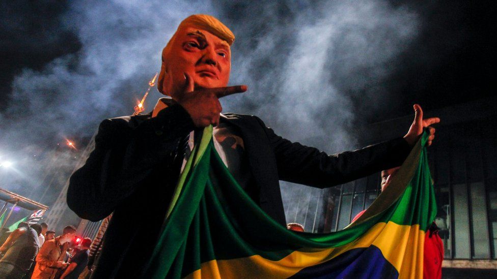 A supporter of far-right lawmaker and presidential candidate for the Social Liberal Party (PSL), Jair Bolsonaro, wears a mask of US President Donald Trump