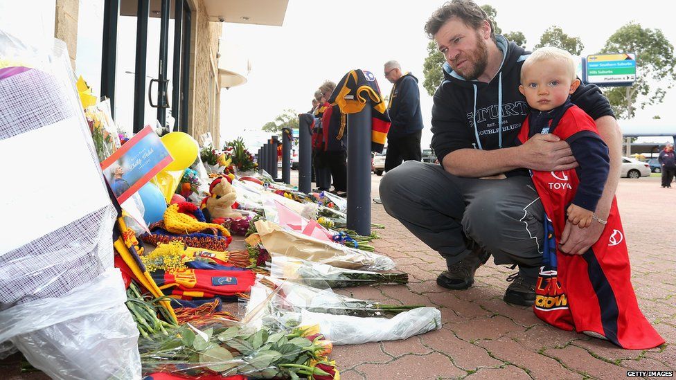 Adelaide Crows fans gather outside the AAMI Stadium in Adelaide, South Australia after Phil Walsh's death, 3 July 2015