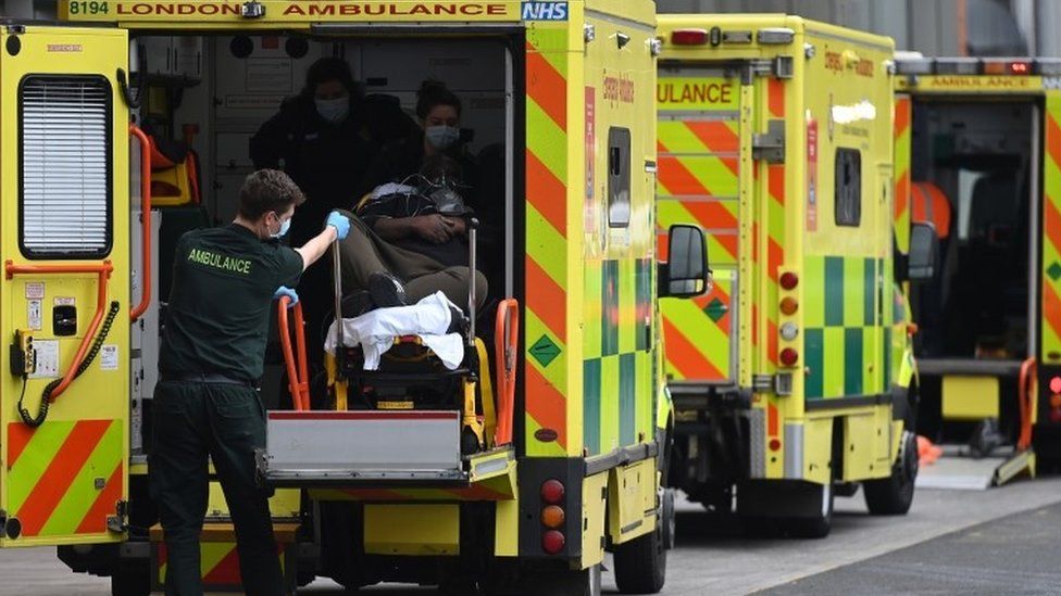 London Ambulance Service staff take a patient out an ambulance