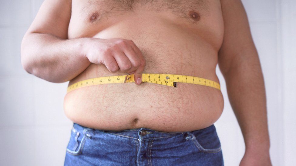 Overweight man with measuring tape