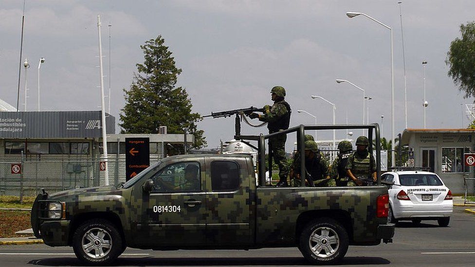 Mexican soldiers patrol the surroundings of Guadalajara international airport, in Guadalajara, Jalisco State, Mexico, on August 15, 2013 as Mexican authorities wait for the arrival of Sandra Avila Beltran, known as the "Queen of the Pacific" for her links to the drug trade, to arrest her after the United States deports her.