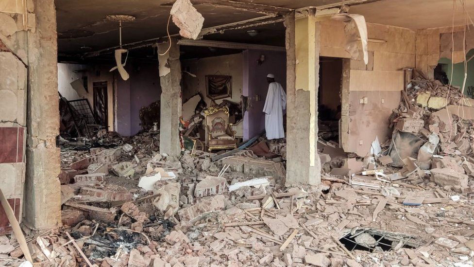 A man walks through the rubble as he inspects a house that was hit by an artillery shell in the Azhari district in the south of Khartoum on June 6, 2023.