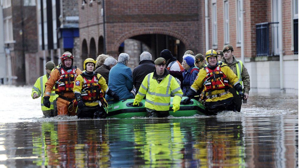 Members of the Army and rescue teams help evacuate people from flooded properties after they became trapped by rising floodwater when the River Ouse bursts its banks in York city centre. Sunday 27 December