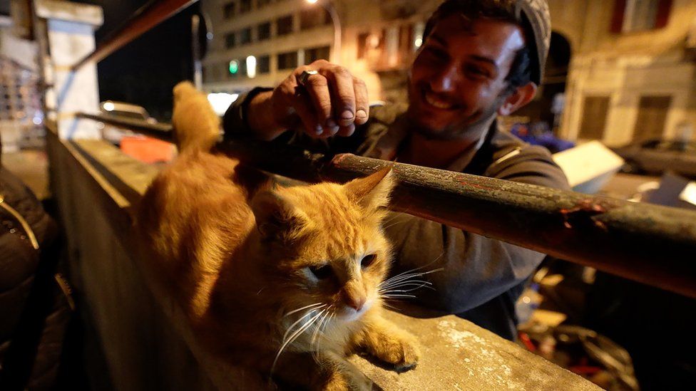 Deiri Fayyad strokes the local cat Amber