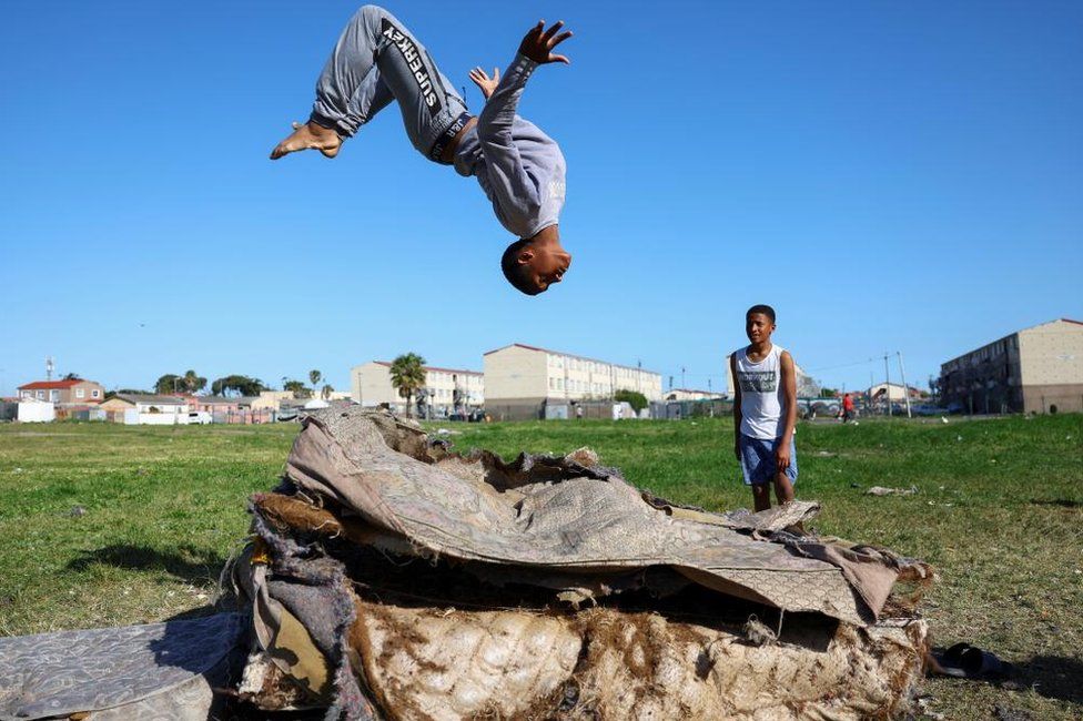 A boy plays on old mattresses in Hanover Park, an area affected by ongoing gang violence in Cape Town, South Africa, September 28, 2022