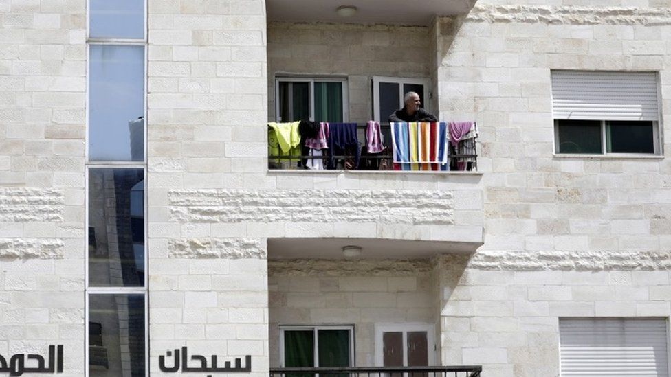 A man looks out from his balcony in Amman, Jordan