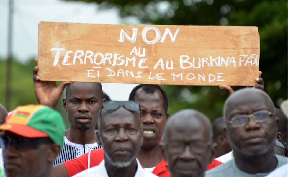 Protestors march holding a placard they take part in a rally "no to barbarism" in central Ouagadougou on August 19, 2017, after a recent attack in the capital of Burkina Faso in which 18 people were killed. Gunmen killed nine locals and nine foreigners as they dined on the terrace of a Turkish restaurant in Ouagadougou late August 13.