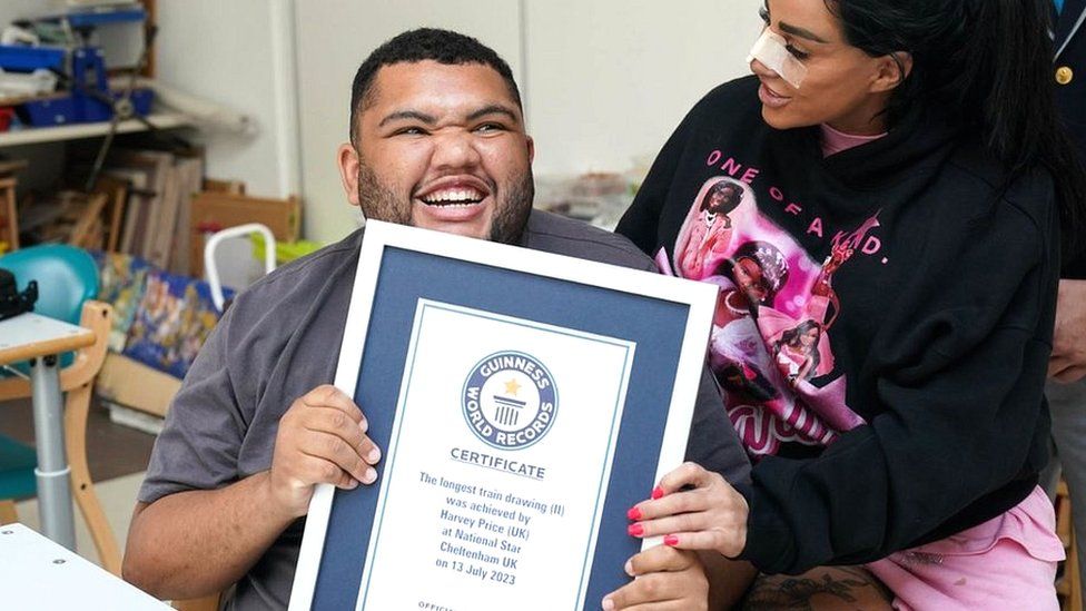 Katie Price and Harvey Price holding his Guinness World Record certificate