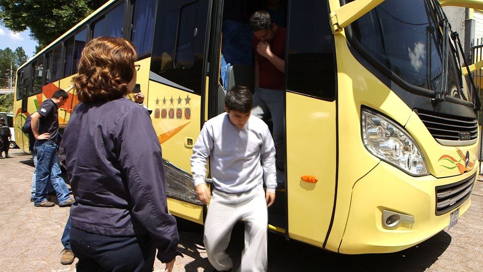 A man deported from the US to El Salvador gets off a bus
