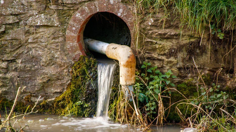 Вода течет из канализации в реку в Великобритании