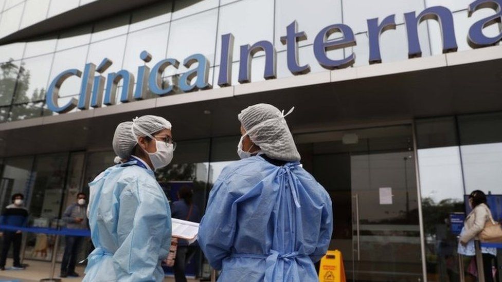 Health personnel stand outside of a private clinic after the last-minute agreement reached between the Government and private clinics to reduce health care prices during the pandemic, in Lima, Peru, 25 June 2020