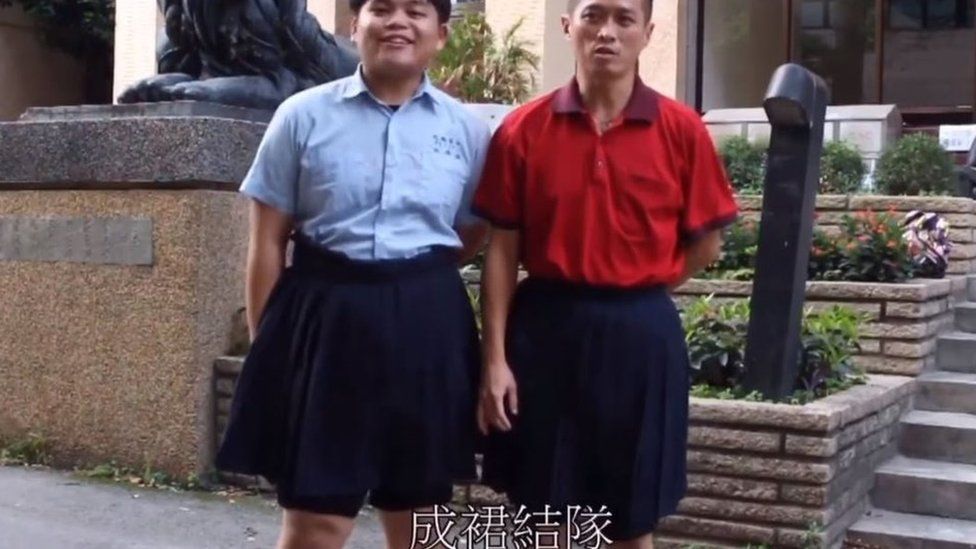 Male student and teacher wearing blue skirts