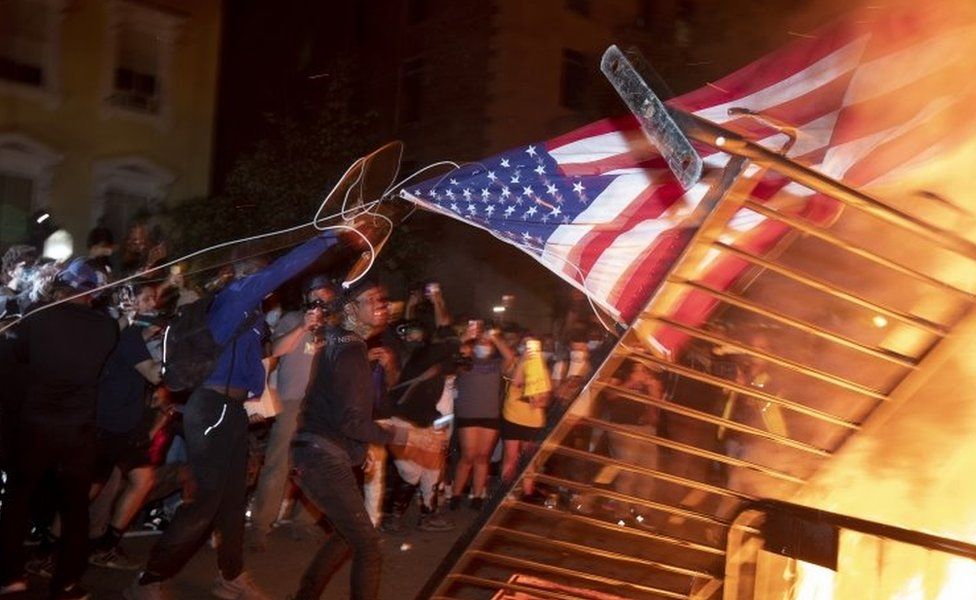 Protesters burn a US flag in Washington DC. Photo: 31 May 2020