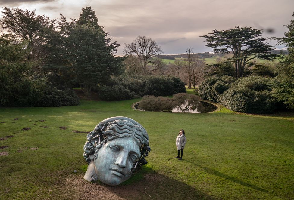 Dominique Lynch views Daniel Arsham's Unearthed, Bronze Eroded Melpomene, on display at the Yorkshire Sculpture Park in Wakefield, West Yorkshire.