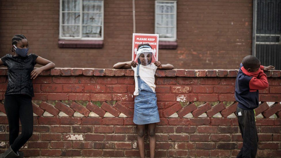 Children keep safe distancing as they queue at a food distribution organised by the grassroots charity Hunger Has No Religion, in Westbury, Johannesburg, on May 19, 2020.