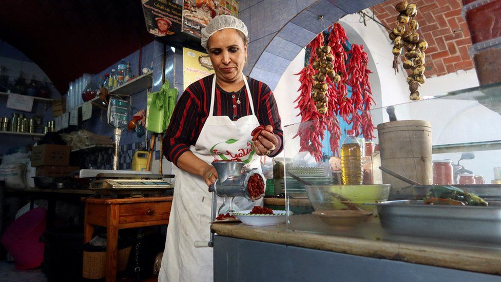 Chahida Boufayed, a Tunisian harissa maker, grinds red peppers to make harissa at her shop in Nabeul, Tunisia October 1, 2023.