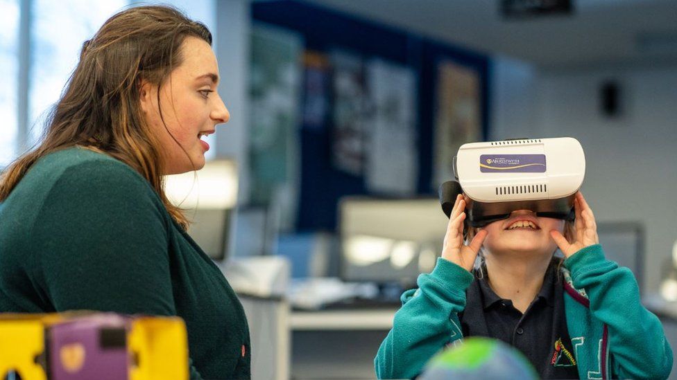 Carys Huntly with a female student testing a VR headset