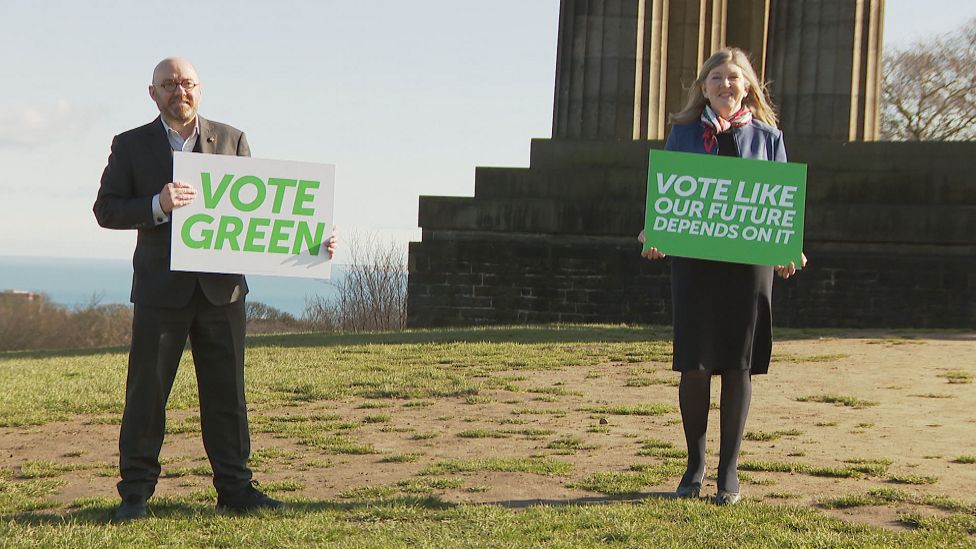 Scottish Green co-leader Patrick Harvie and MSP Alison Johnstone hold signs, urging voters to "Vote Like Our Future Depends On It"