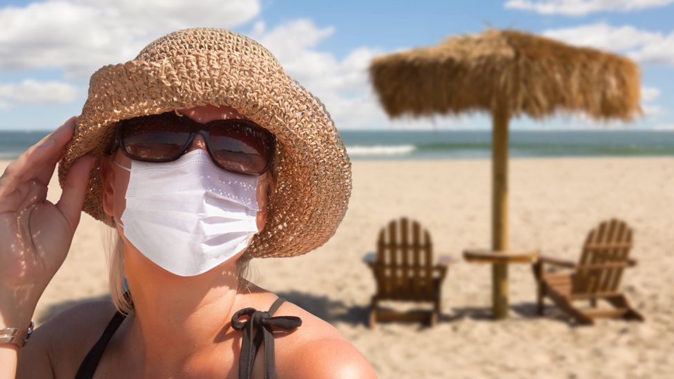 Woman wearing mask on the beach