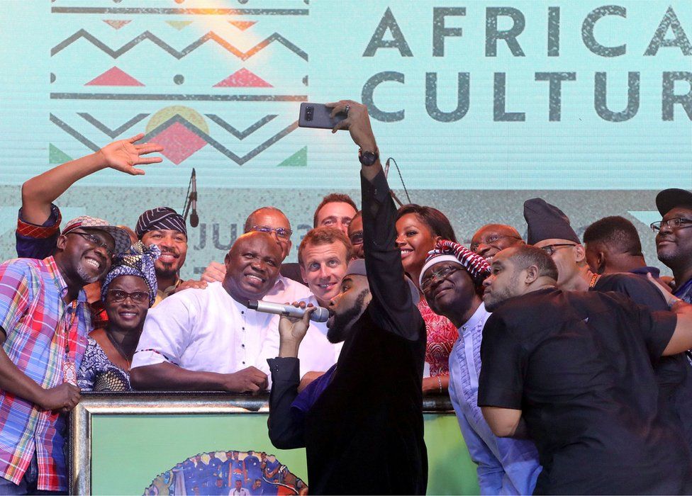 French President Emmanuel Macron (C) poses with Nigerian artists at the Afrika Shrine in Lagos, Nigeria, July 3, 2018.