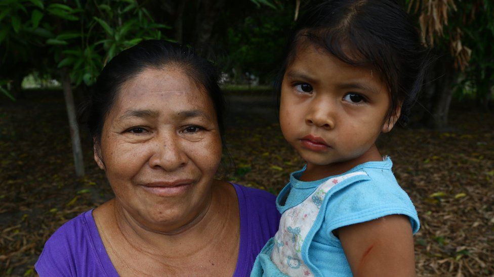 Picture of a Wai-Wai woman and a child smiling to the camera