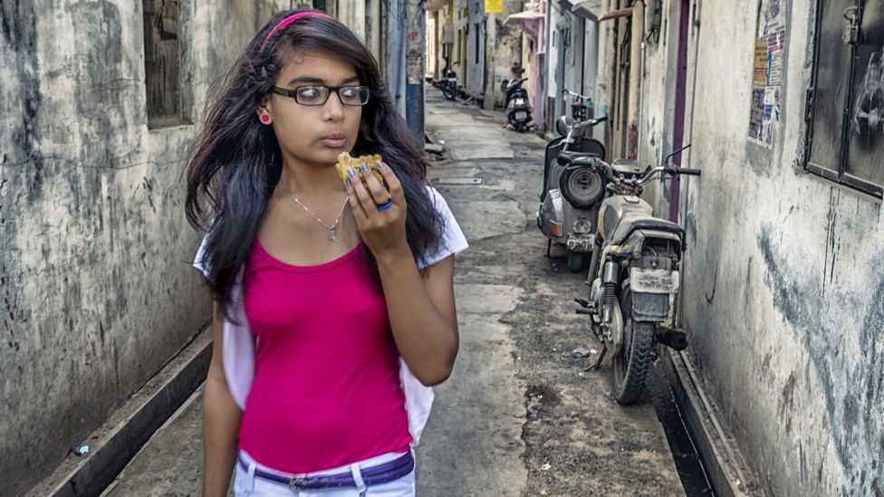 Young women eating a samosa