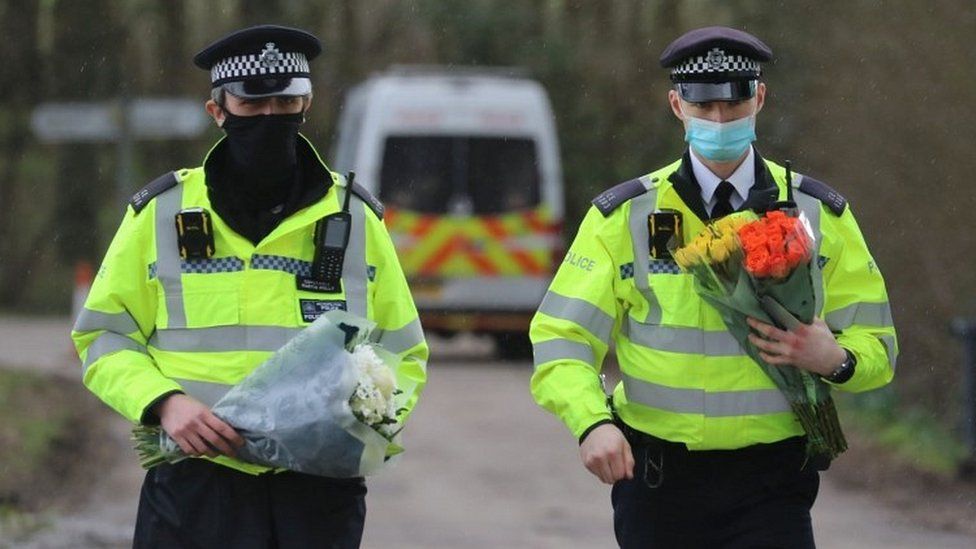 Police holding floral tributes