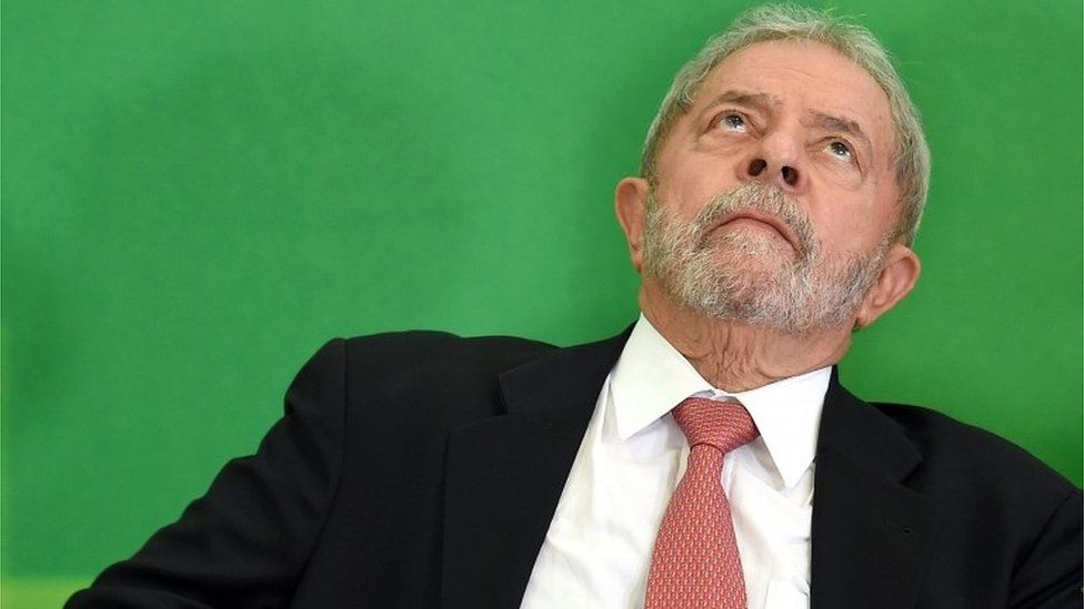 Former Brazilian president Luiz Inacio Lula da Silva gestures next to Brazilian president Dilma Rousseff (out of frame) after Lula's sworn in as chief of staff, in Brasilia on March 17, 2016