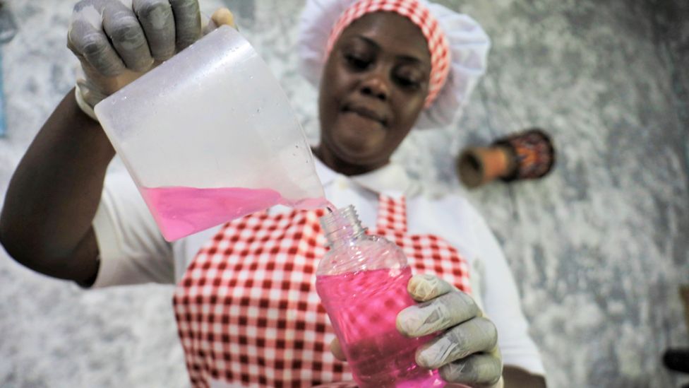 A woman pouring liquid soap into a bottle in Abidjan, Ivory Coast - Wednesday 1 April 2020
