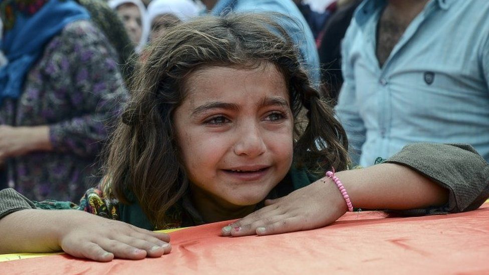 A girl cries as she leans on the coffin of a relative killed during clashes between Turkish forces and the PKK in the city of Cizre