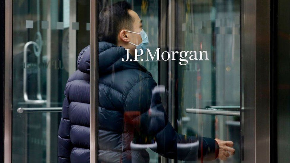 A worker entering JP Morgan offices in New York in March