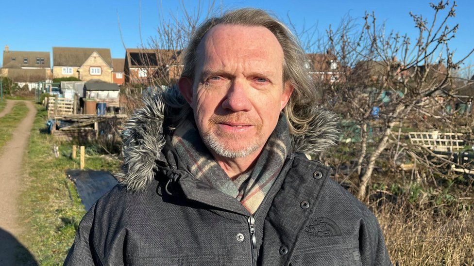 Jonathan Harris with long hair and beard in an allotment