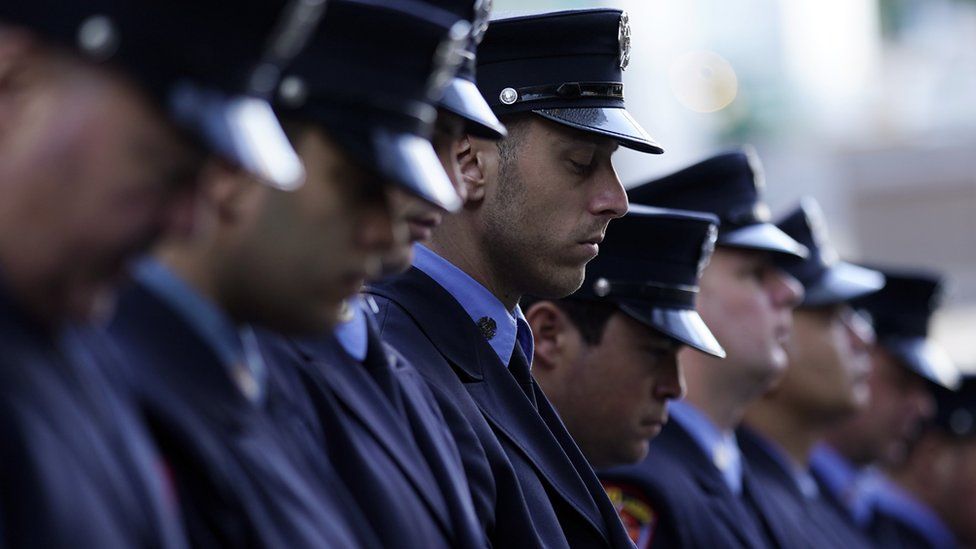 Members of the New York Fire Department mark a moment of silence, close to Ground Zero during commemorations at the 9/11 Memorial in New York, USA, 11 September 2021