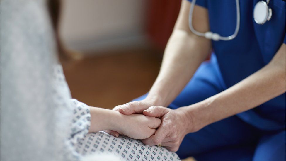 Nurse comforts patient - stock shot