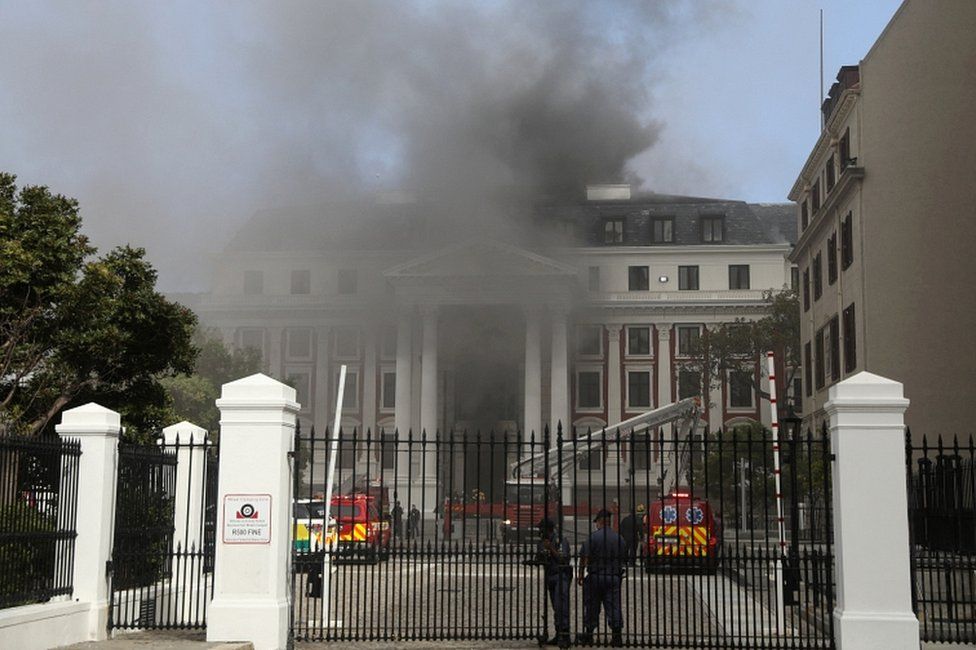 Firefighters work among the smoke after a fire broke out in the Parliament in Cape Town, South Africa, on 2 January 2022