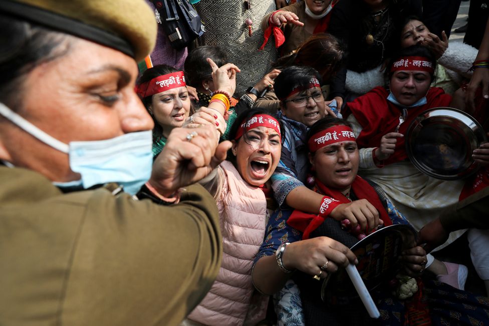 A police officer tries to restrain supporters of the women's wing of India's main opposition Congress Party, during a protest in Delhi, India, on 30 November 2021