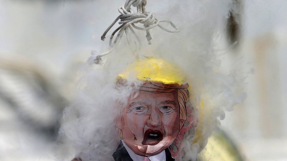 A pinata of Republican presidential candidate Donald Trump hangs from a noose while it is burning during a protest at Hemiciclo Juarez monument in Mexico City, Mexico, October 12, 2016