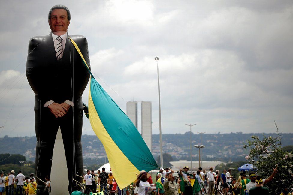 Sympathisers of Brazilian President-elect, Jair Bolsonaro, walk past a giant figure of the future president before the beginning of the inauguration ceremony, in Brasilia, Brazil, 01 January 2019