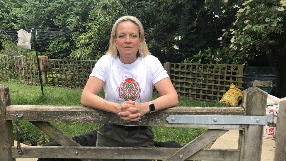 Caroline Wood leaning over a garden gate