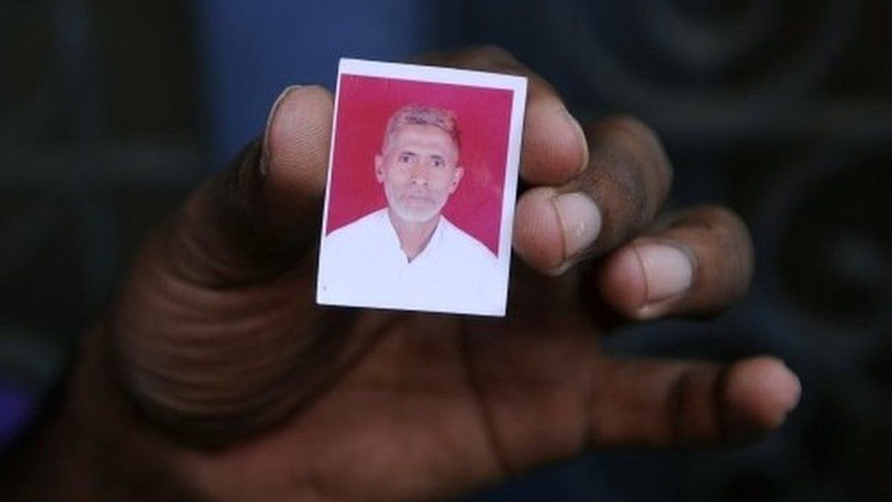 A relative holds a photograph of slain Indian villager Mohammad Akhlaq at his home in the village of Bisada,