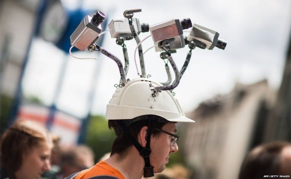 Chairman of Hesse"s Pirate Party Volker Berkhout wears a hat with mock surveillance cameras during a demonstration against spying activities of the US intelligence agency NSA and its German partner service BND in Frankfurt am Main, central Germany, on May 30, 2015.