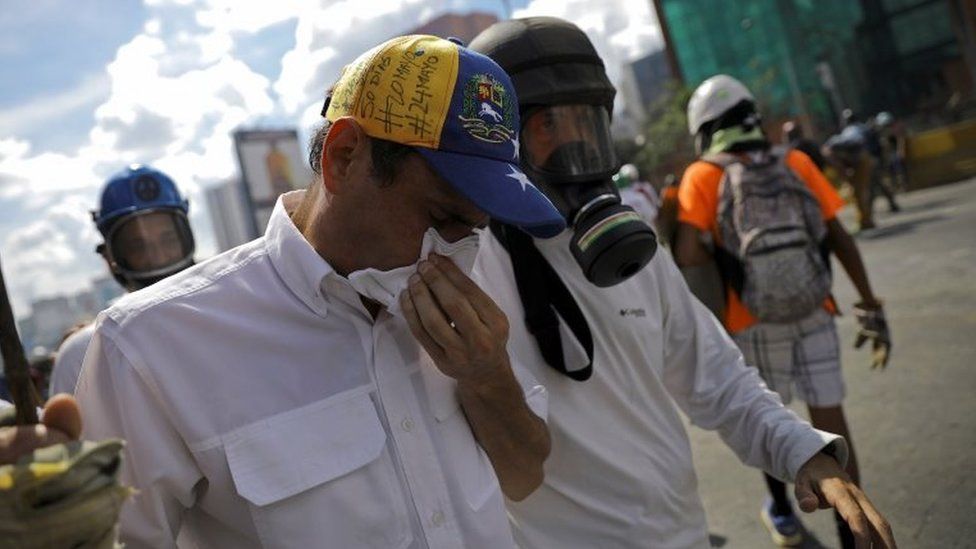 Venezuelan opposition leader Henrique Capriles reacts to tear gas effects during riots at a march to state Ombudsman's office in Caracas, Venezuela May 29, 2017.