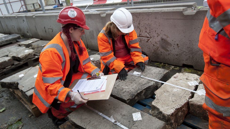 Volunteers in London recording a gravestone before it is removed ahead of the construction of HS2.